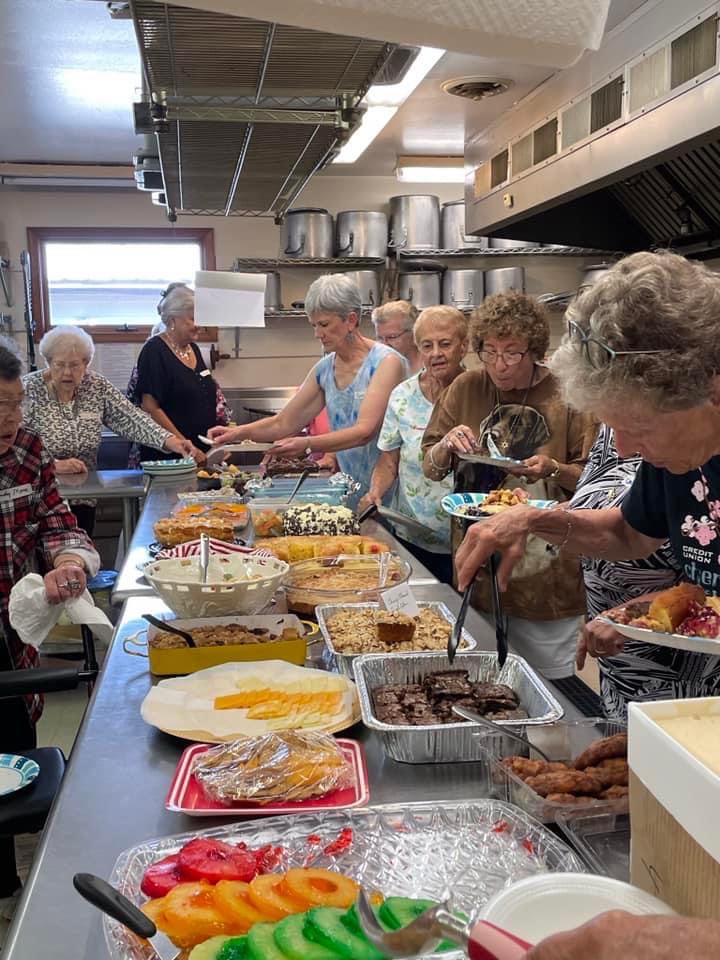 The travel club enjoys a buffet lunch for their annual picnic