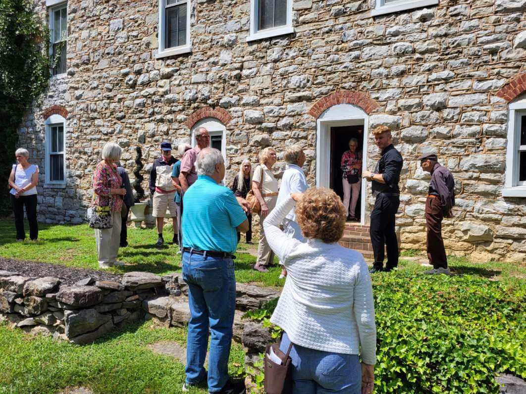 A group of people are outside of a historic building at Jordan Springs Event Center, VA